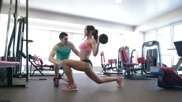 女孩做弓步在健身房的教练. — 图库视频影像