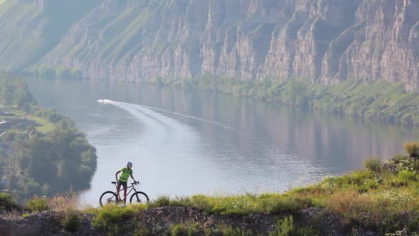 Die sportliche Frau mit dem Fahrrad in der Gebirgslandschaft. — Stockvideo