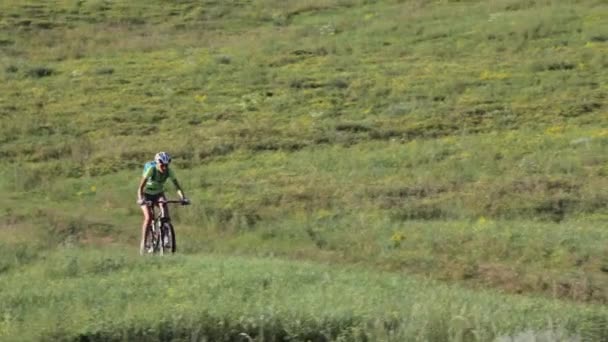 Donna ciclista corse in bicicletta una strada sterrata, vista posteriore — Video Stock