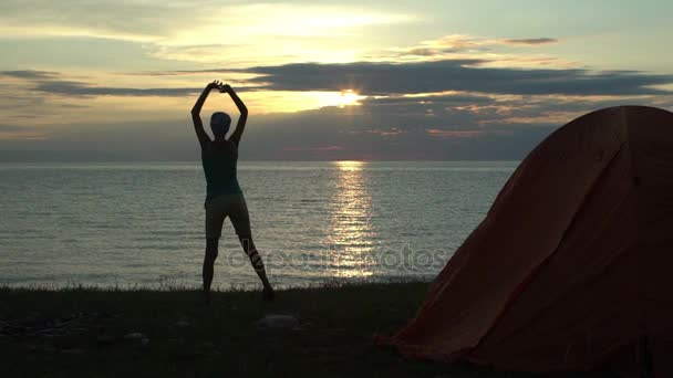 Kobieta o camping patrząc na wschód słońca rano — Wideo stockowe