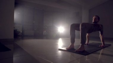 Esnek adam elindeki bir spor salonunda duruyor.