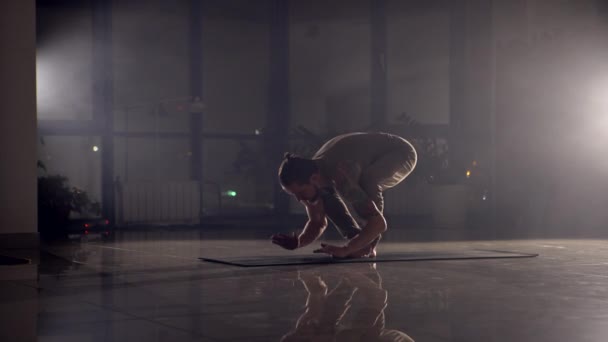 Homem flexível está em suas mãos em um ginásio . — Vídeo de Stock