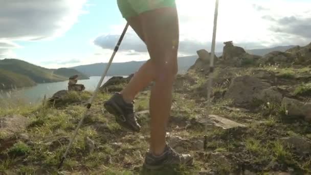 Junge Frau mit Rucksack wandert durch Berge und See — Stockvideo