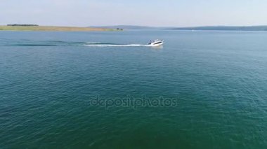 Havadan çekim tekneler göl kenarında. Bir tekne peşinde.