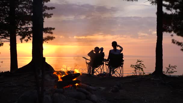 Μητέρα με παιδί κάθεται κοντά Campfire το βράδυ. — Αρχείο Βίντεο