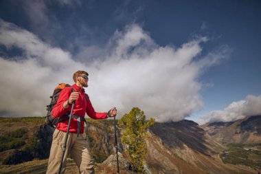 Yakışıklı genç sakallı hiker uzağa arıyorsunuz bir kanyonun kenarında oturan