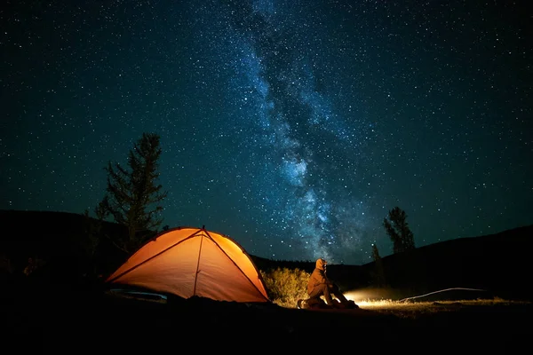 Homem turista perto de sua tenda acampamento à noite . — Fotografia de Stock