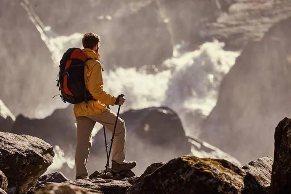 Wanderer wandert mit Rucksack zum Wasserfall — Stockfoto