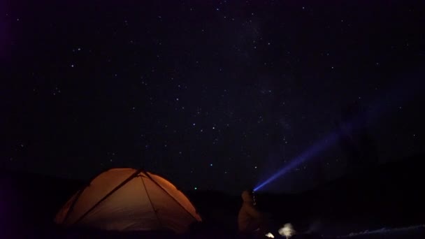 Rörliga stjärnor ovanför camping på natten. Mannen har lägereld. — Stockvideo