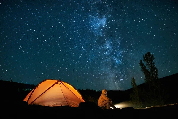 Człowiek turystycznych w pobliżu jego obozu namiotu w nocy. — Zdjęcie stockowe