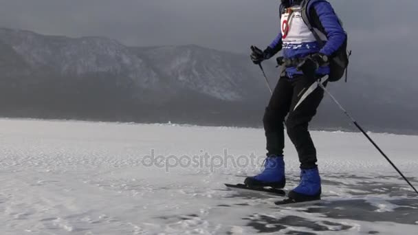 Man zijn schaatsen op het ijs van bevroren Baikalmeer in een zonnige dag — Stockvideo