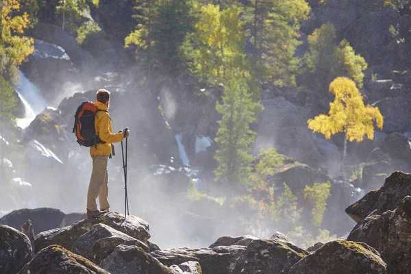 Wanderer wandert mit Rucksack am Gebirgsfluss — Stockfoto