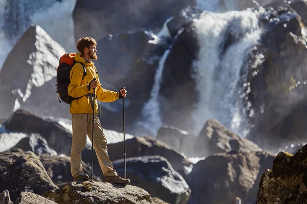 Wanderer wandert mit Rucksack zum Wasserfall — Stockfoto