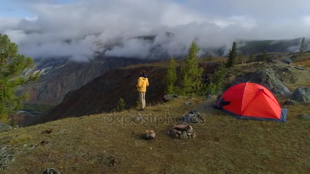 Εναέρια πλάνα από έναν άνδρα να στέκεται κοντά σε μια σκηνή μπροστά από την κοιλάδα του βουνού. 4k — Αρχείο Βίντεο