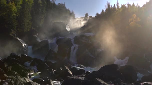 Imágenes de una cascada rocosa en una retroiluminación . — Vídeos de Stock