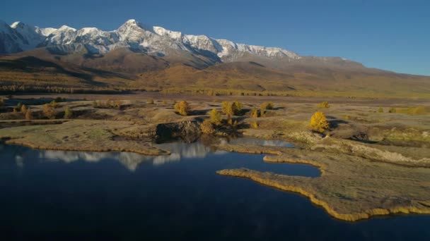 Aérea. Volando sobre el hermoso lago cerca de las montañas. Panorama. Otoño . — Vídeos de Stock