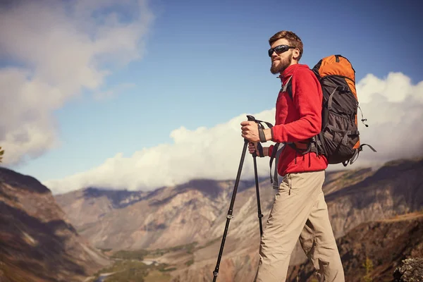 Schöner junger bärtiger Wanderer, der am Rande einer Schlucht steht und wegschaut — Stockfoto