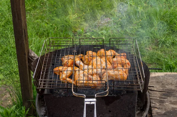 グリルで鶏の羽 バーベキューだ 屋外で料理する 庭で鶏の羽を焼く 古い摩耗グリル — ストック写真