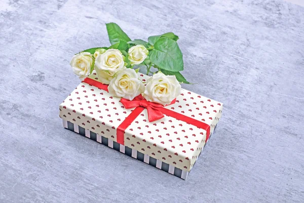 Geschenkdoos met witte rozen op grijze achtergrond — Stockfoto