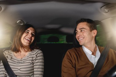 Arabada oturan, emniyet kemeri takan mutlu beyaz bir çiftin portresi. Seyahat sırasında gülümsüyor ve konuşuyor. Güvenli sürüş ve seyahat konsepti.