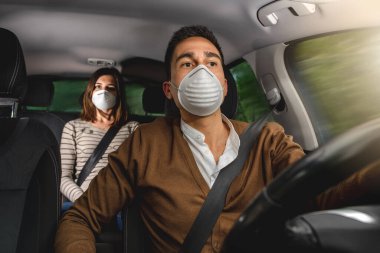 Virüs koruması için tıbbi maske takan ciddi bir çift. Sosyal uzaklık ve kemerlerinizi bağlayın. Sağlık, güvenlik ve salgın konsepti. Koronavirüs salgını sırasında araba kullanmak