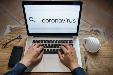 Üst görüşlü adam klavyede Coronavirus hakkında bilgi arıyor. Sahte haber ya da güncel konsept..