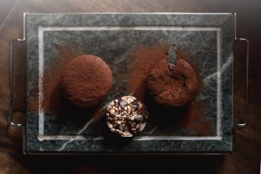 Çikolatalı pastanın en üst görüntüsü tatlı mono porsiyonunu taş tepside sunar. Dikey resim.