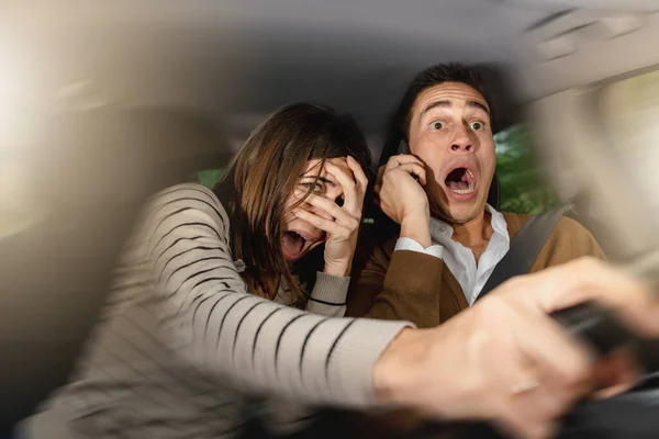 운전자 남성은 자신의 위치에서 운전하는 척하면서 전화와 핸들을 잡는다 사람들은 — 스톡 사진