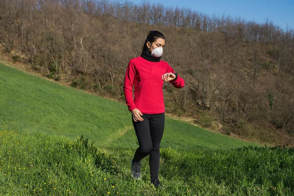 Koronavirüs için koruyucu yüz maskesi takan sportif bir kadın. Spor ve salgın konsepti.