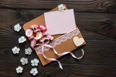 Üzerinde pembe çiçekler ve bayram için bir tebrik kartı olan bir zarf.