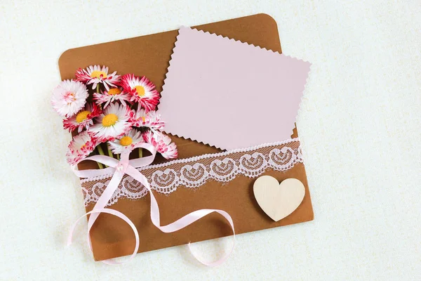 母亲节 背景上贴有粉色野花和白色卡片的信封 — 图库照片