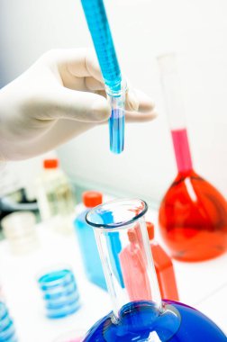 Laboratuvarda virüsü analiz eden bilim adamı. Elindeki 19 kan ve kimyasal reaksiyon tüpü. Coronavirüs aşısı araştırması. 