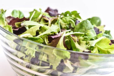 Beyaz arka planda, cam kasenin beyazından, karışık salatalı, sadece yeşil tarlada taze ve mevsime uygun.