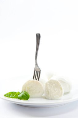 Zarif ve lezzetli İtalyan yemeği. Beyaz arka planda fesleğenli, şiş çatallı ve domatesli Campania 'dan bir bufalo mozzarella.