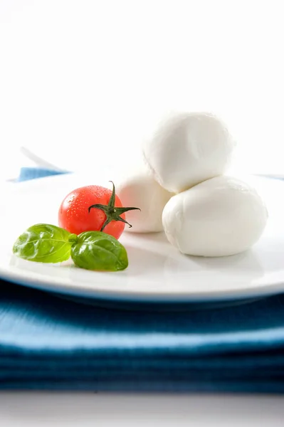 意大利菜雅致可口 配上来自坎帕尼亚的道普水牛莫扎拉和白色背景的罗勒番茄 并放在蓝色餐巾上 — 图库照片