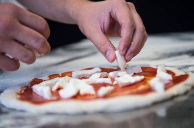 Maya unu ve su ile ev yapımı gerçek bir İtalyan pizzası hazırlamak için çeşitli aşamalarda çalışan bir pizza şefinin ellerinin ayrıntıları..