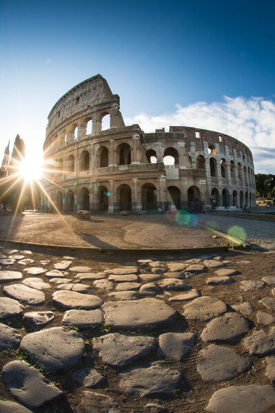 View of the Colosseum in Rome and morning sun, and roman stones, Italy, Europe