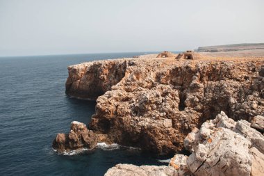 Kırmızımsı taş Menorca uçurumu güneşli bir günde