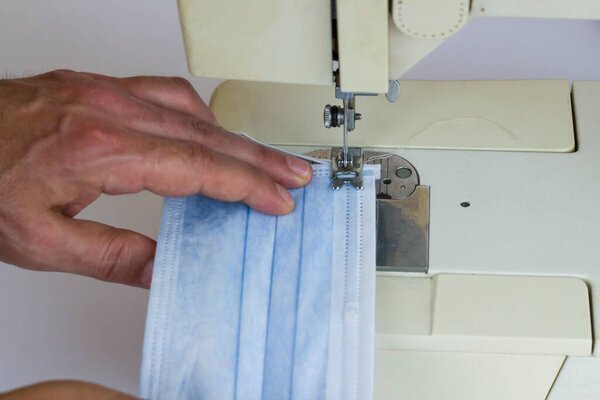 Surgical face mask is sewn on the sewing machine,close up