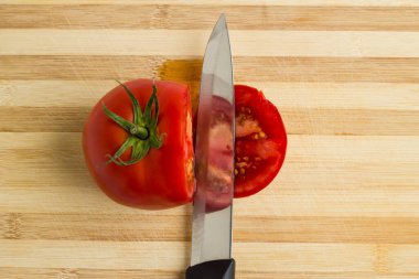 Kesme tahtasında bıçakla dilimlenmiş domates, üst manzara..