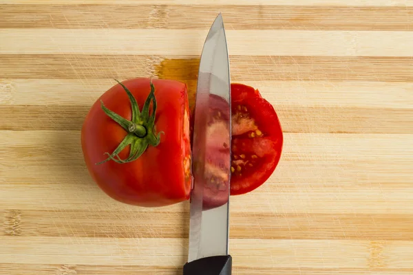 Kesme tahtasında bıçakla dilimlenmiş domates, üst manzara..