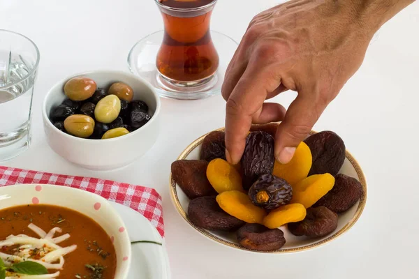 El, kurutulmuş yaş meyvesini Ramazan 'da yemek masasına koymak. Kapatın.