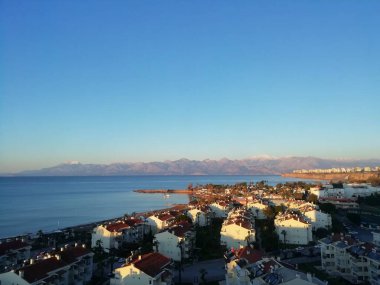 Antalya 'daki dağların ve denizin arka planında gün batımı