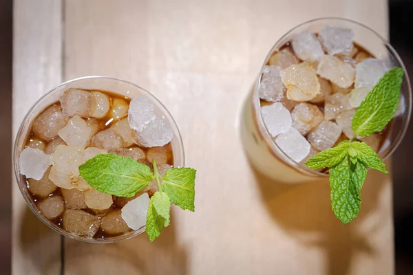 İki bardak mojito, su buzlu. Tahta üzerinde zenital düz.