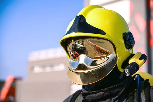 firefighter with yellow helmet and reflective watching on race track in broad daylight