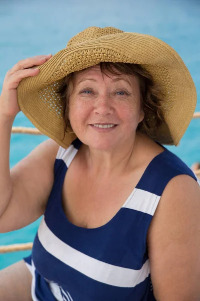 Mujer mayor sonriente con sombrero en la playa de mar —  Fotos de Stock