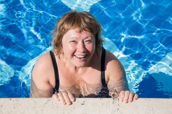 Mujer mayor activa nadando en agua azul de la piscina — Foto de Stock