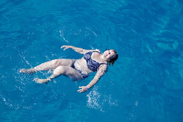 Femme âgée active nageant dans l'eau de mer bleue — Photo