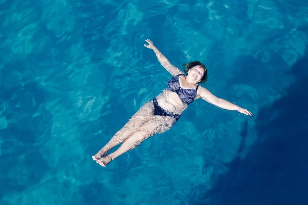 Mujer mayor activa nadando en agua de mar azul Imágenes de stock libres de derechos