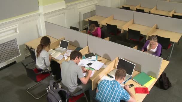 Estudiantes lanzando aviones de papel al estudiante — Vídeo de stock